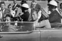 FILE - In this Nov. 22, 1963 file photo, President John F. Kennedy waves from his car in a motorcade in Dallas. Riding with Kennedy are First Lady Jacqueline Kennedy, right, Nellie Connally, second from left, and her husband, Texas Gov. John Connally, far
