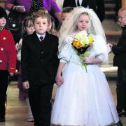 Daniel Pilkington, six, as Prince William and Ceira Fraser-Hobbs, seven, as Kate Middleton leave St Mary’s Church, Bampton, after a mock wedding