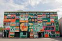 The vibrant artwork, now adorning the front of Greencity Wholefoods' building, represents the cooperative's members, a total of more than 50