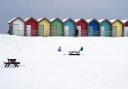 People ride sledges besides the beach huts at Blyth in Northumberland (Owen Humphreys/PA)
