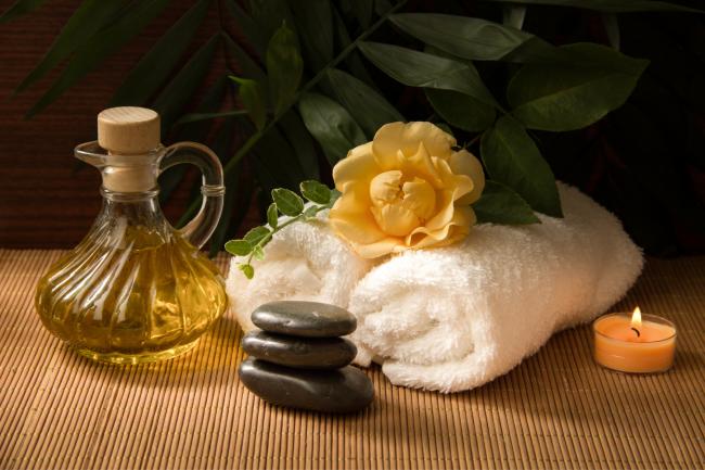 Spa treatments, towel and candle. Credit: Canva